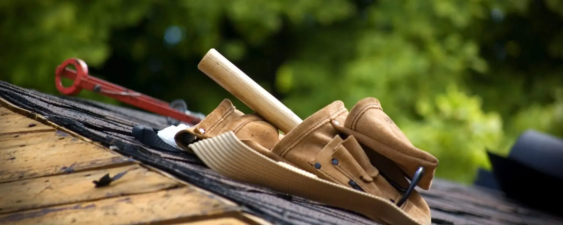 Professional roofing tools laid out on wooden shingles