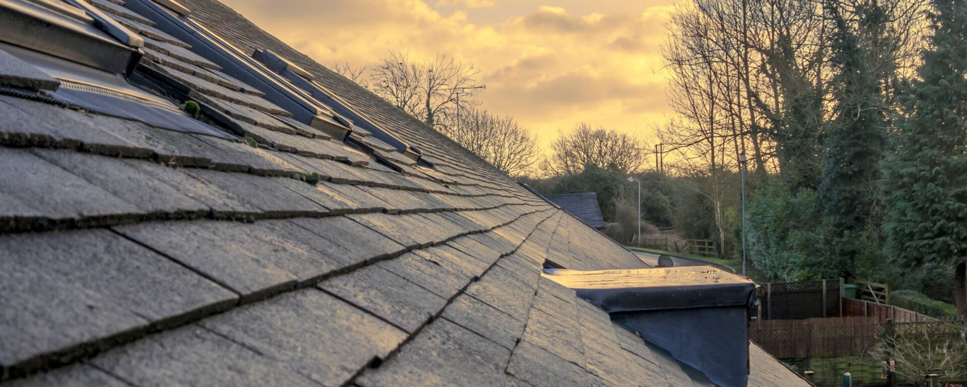 Slate roof shingles with dormer vent at sunset residential home