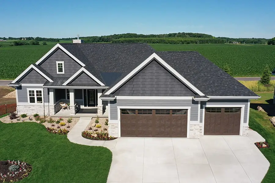 Modern two-story home with gray siding, white trim, and two-car garage