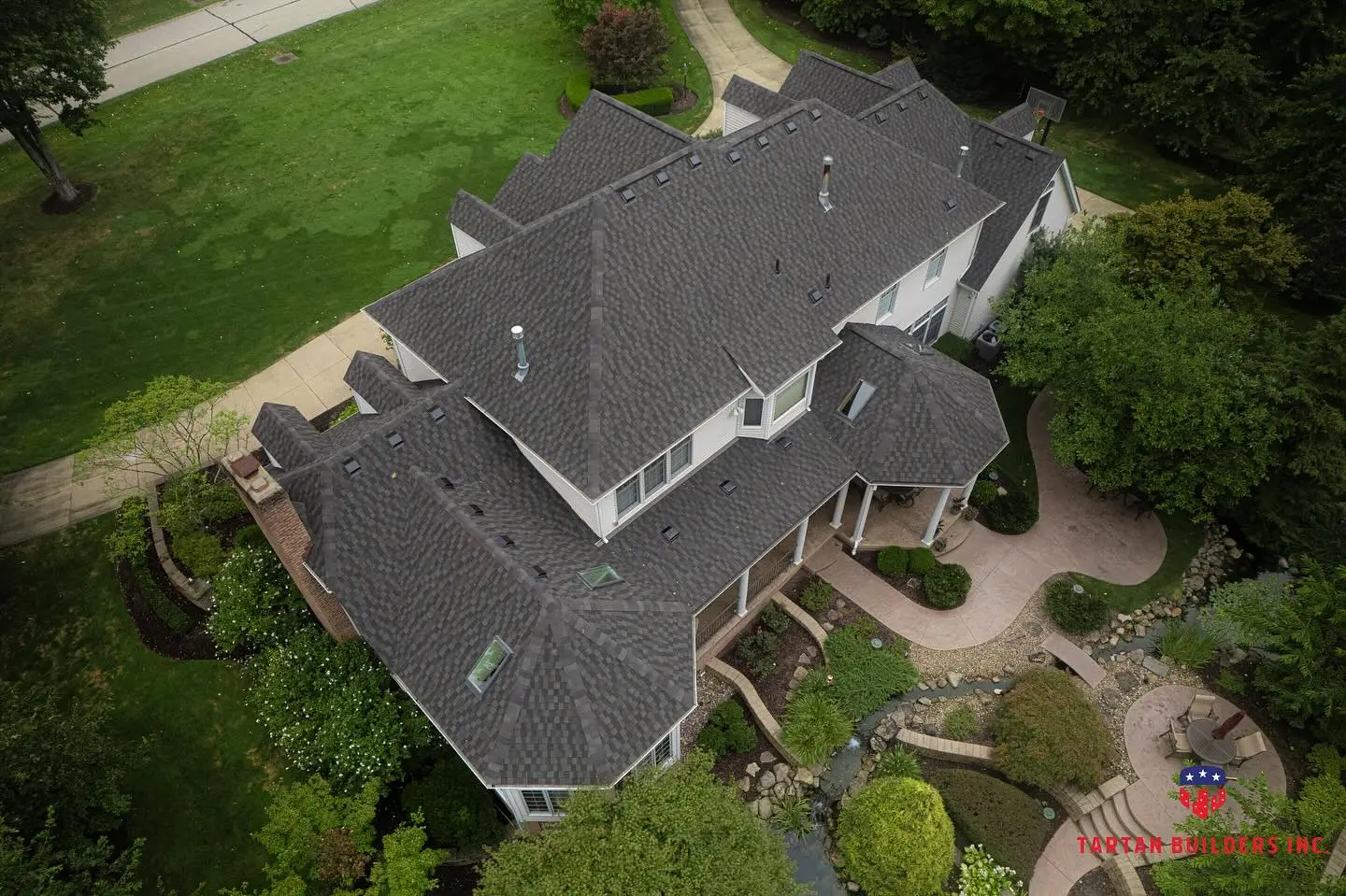 Aerial view of residential home with dark gray shingle roof replacement