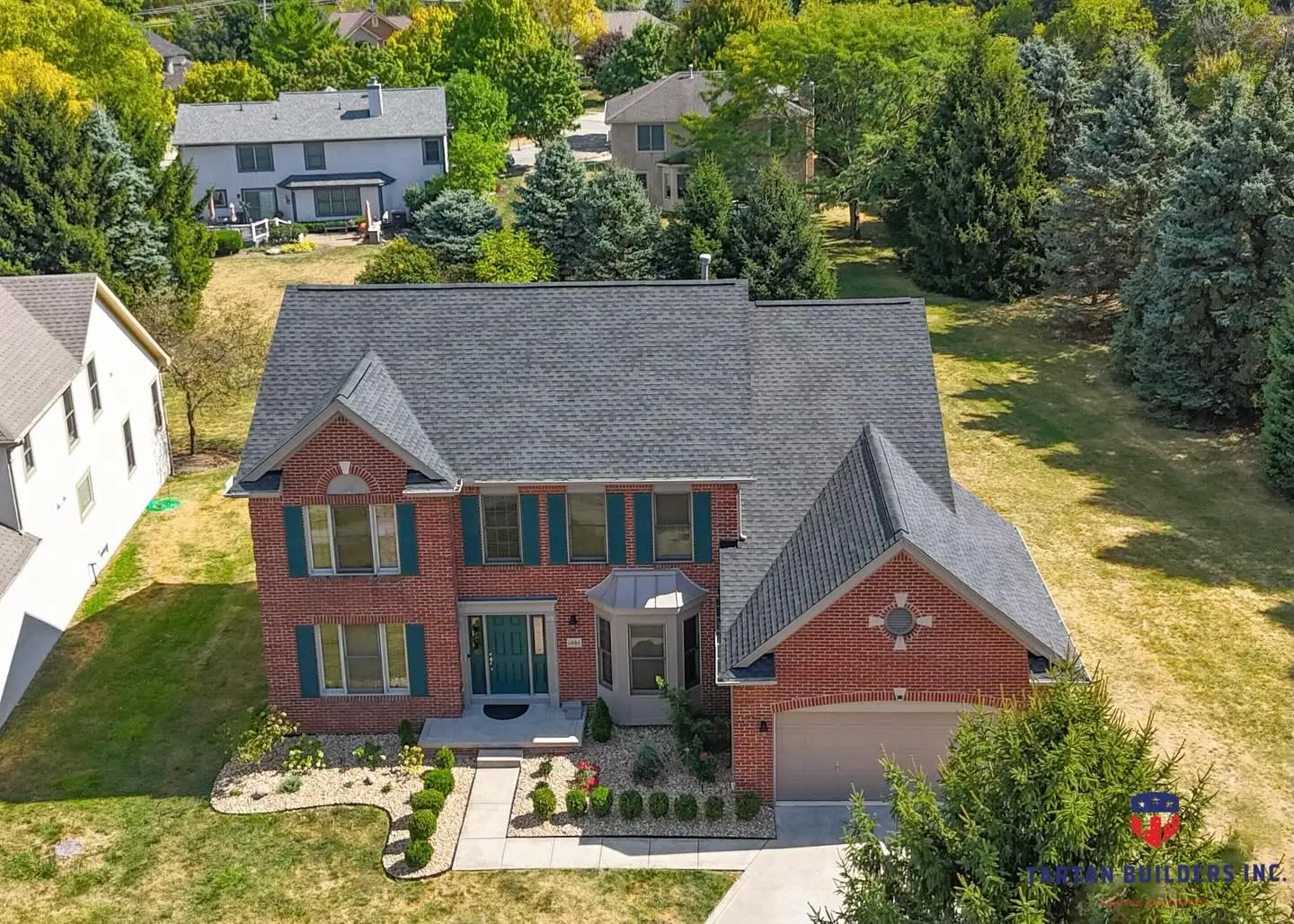 Red brick two-story house with gray roof and attached garage