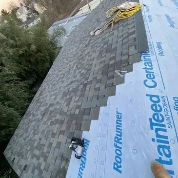 Roofer installing architectural shingles on a residential home