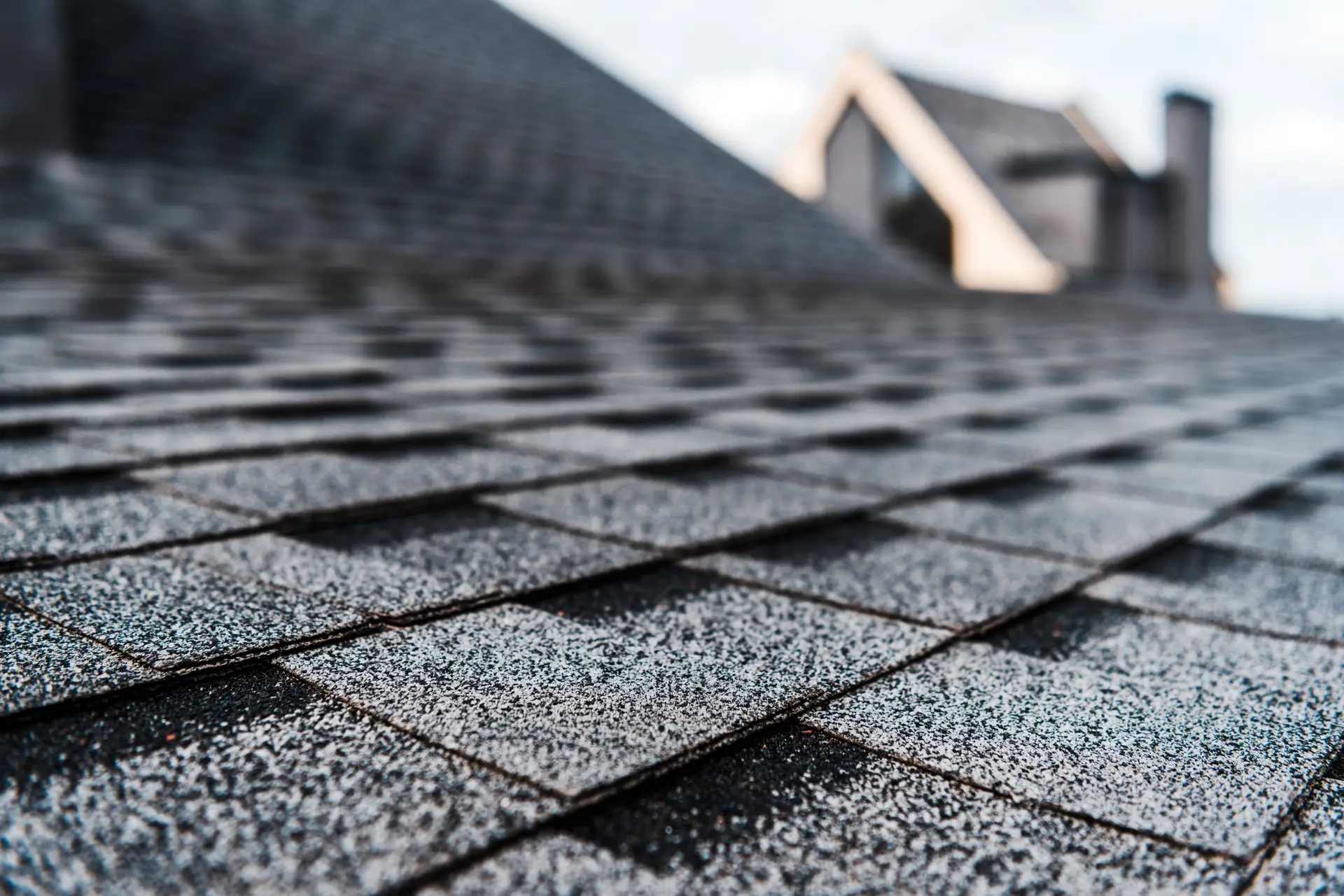 Close-up of gray architectural asphalt shingles showing texture and wear