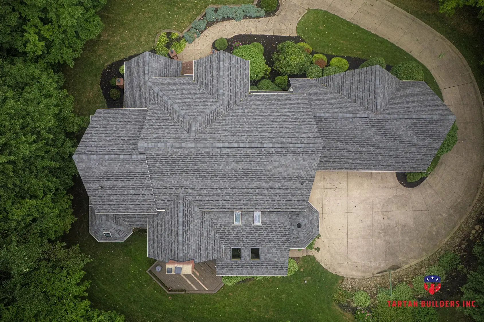Aerial view of large residential home with gray architectural shingle roof
