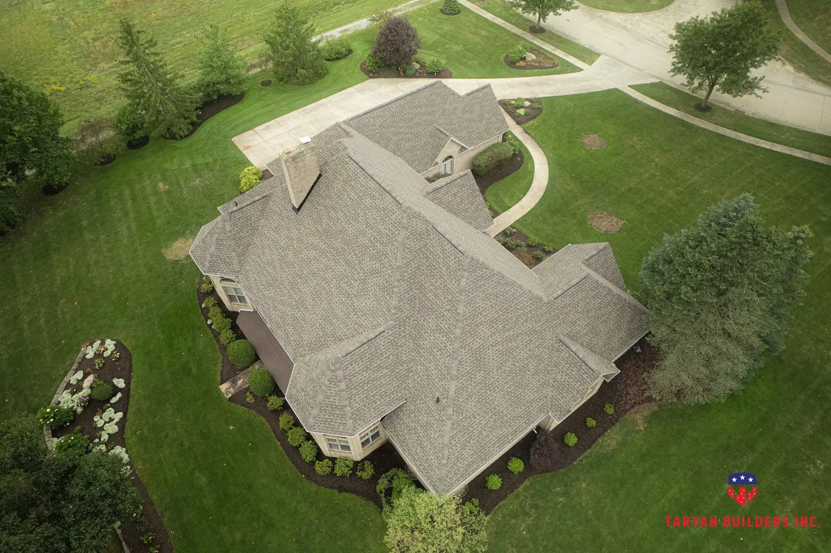Aerial view of large residential estate home with new gray asphalt shingle roof installation