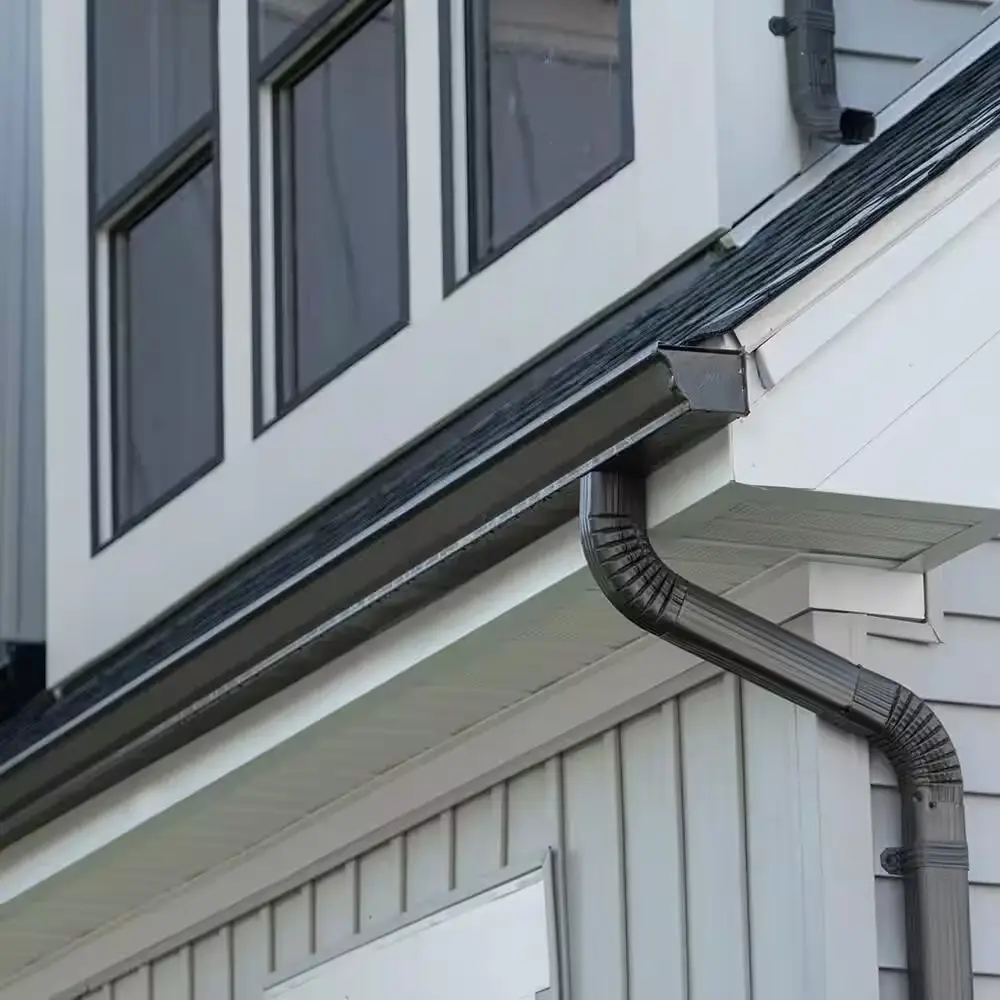 Black seamless gutter system installed on a white residential home